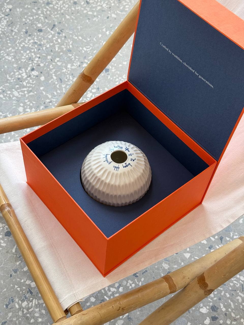 The porcelain vase resting in its navy-and-orange presentation box