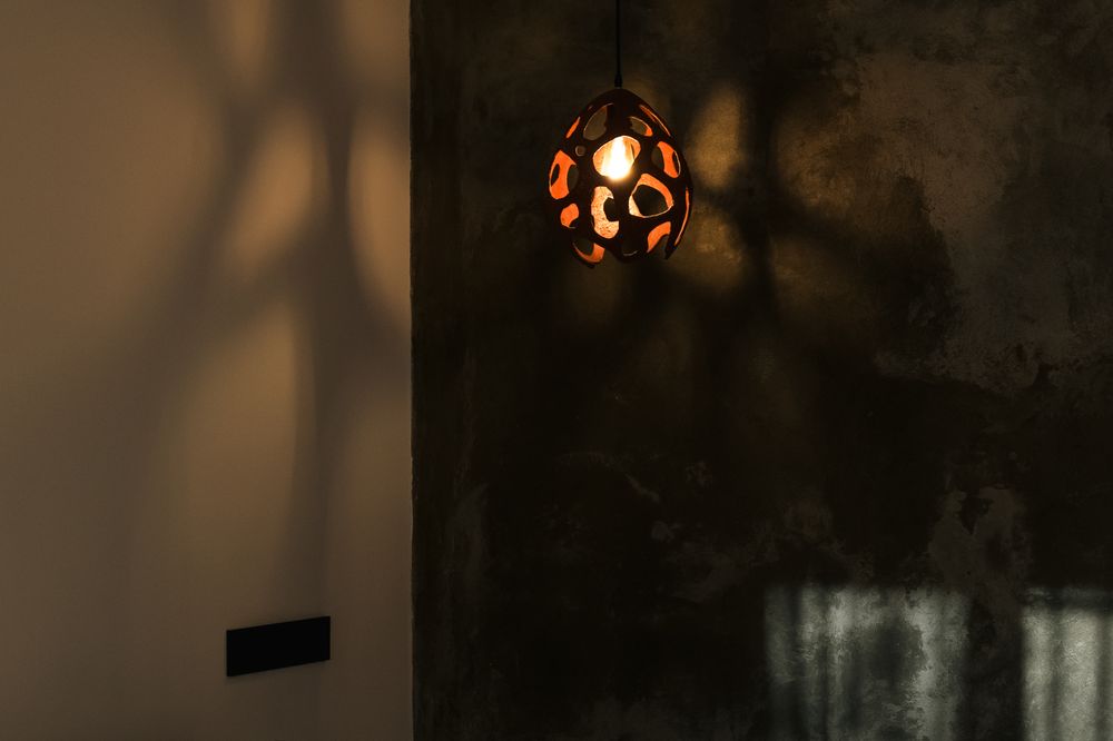 A cosy bedroom at Debatoun with a handmade ceramic lamp