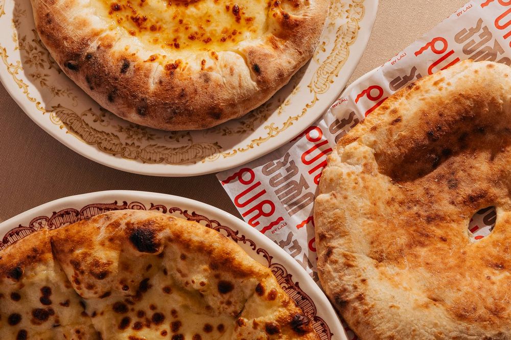 Khachapuri and fire-baked puri bread on patterned plates
